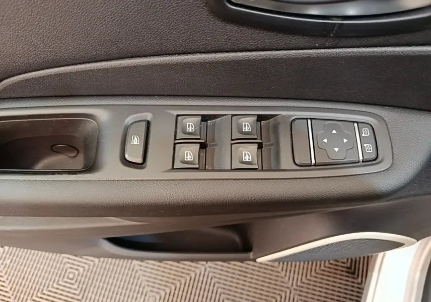 Vue rapprochée des commandes des vitres électriques et réglages des rétroviseurs côté conducteur d'un Renault Captur gris clair.