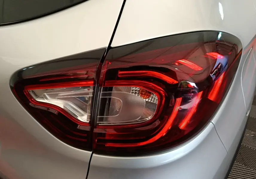 Gros plan sur le feu arrière droit rouge et blanc du Renault Captur gris clair, version 2018 Zen TCe 90.