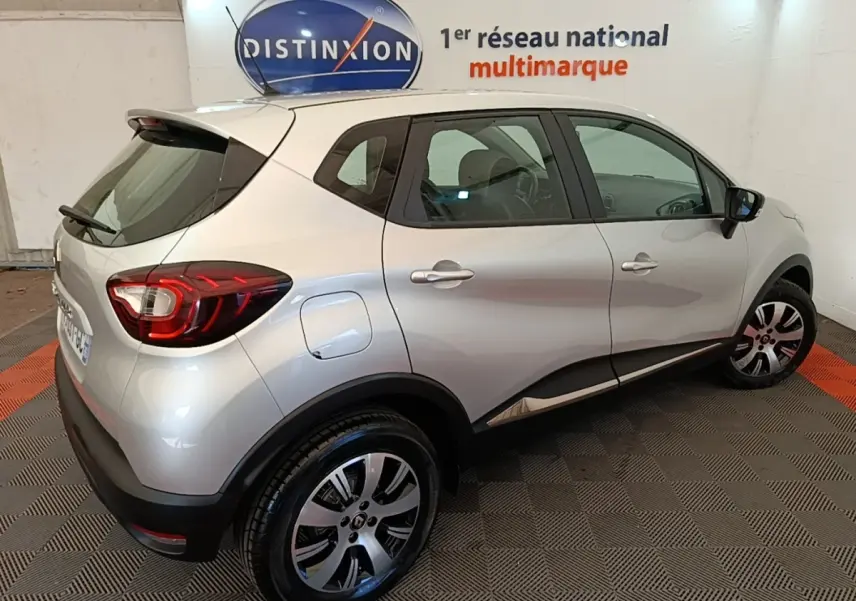 Vue 3/4 arrière droite d'un Renault Captur gris clair 2018 avec feux LED et jantes alliage.