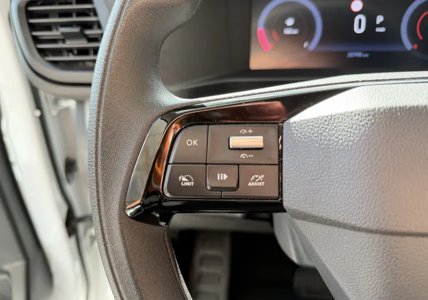 Gros plan sur les commandes au volant à gauche du tableau de bord du FIAT Scudo Fourgon blanc 2025.