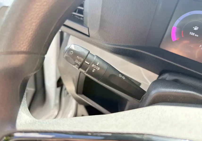 Gros plan sur la manette de commande d’éclairage et clignotants du FIAT Scudo Fourgon blanc, tableau de bord partiellement visible.