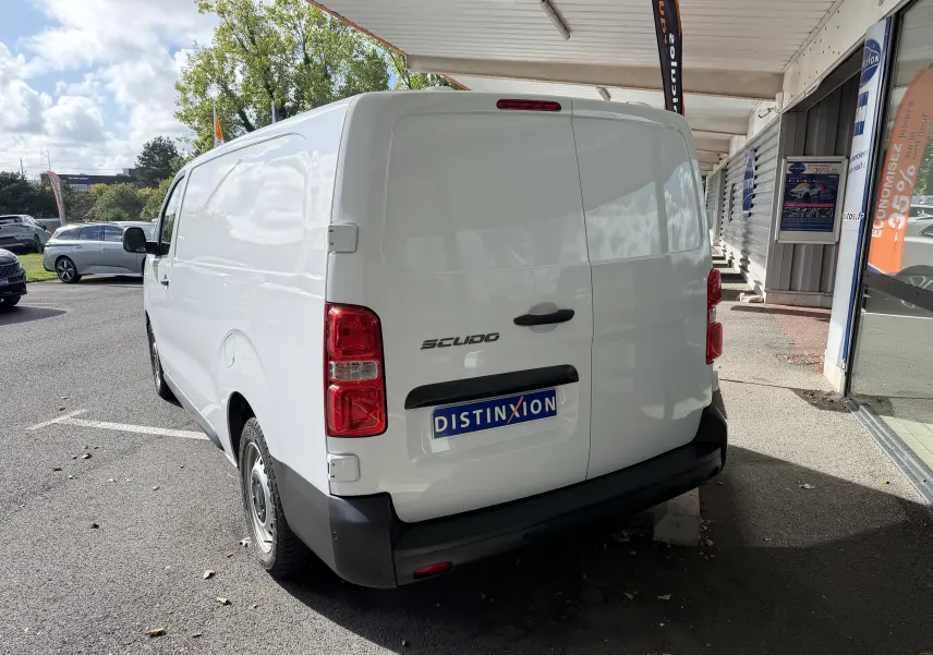Vue 3/4 arrière droite d’un FIAT Scudo Fourgon blanc, avec portes arrière fermées et jantes tôles grises 17 pouces.