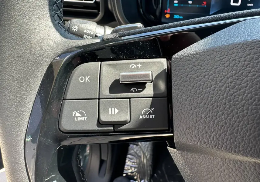 Gros plan sur les commandes multifonctions à gauche du volant cuir du Citroën Berlingo 2026 Kiama Blue.