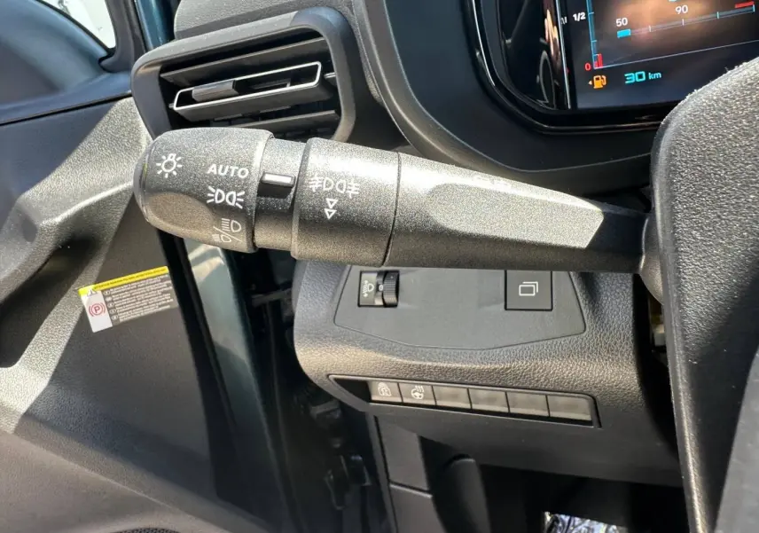 Gros plan sur la commande des phares à gauche du volant dans l’habitacle du Citroën Berlingo Kiama Blue.
