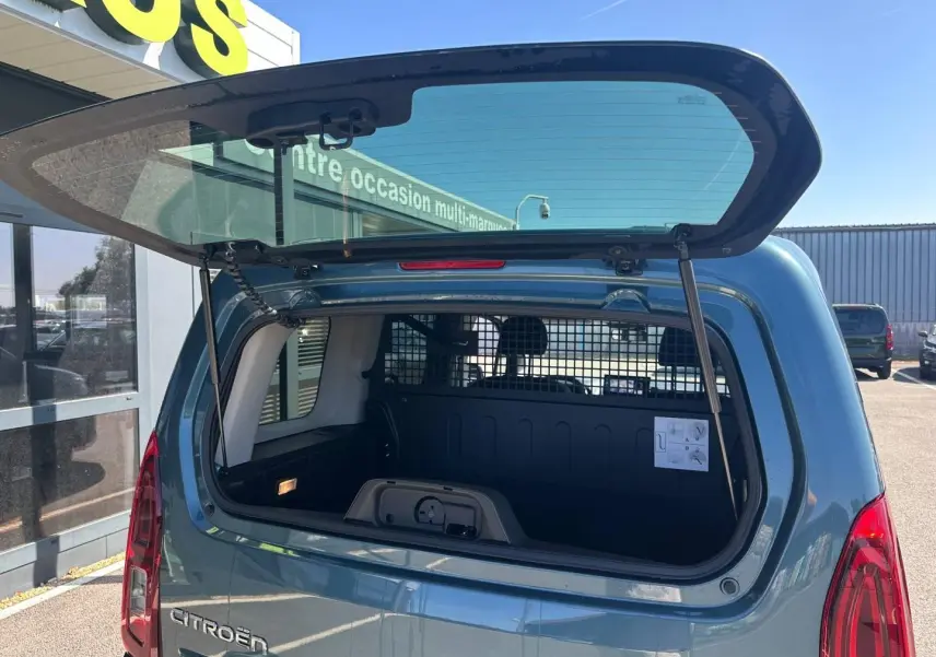 Coffre ouvert en vue arrière d’un Citroën Berlingo Kiama Blue avec cloison de séparation visible.