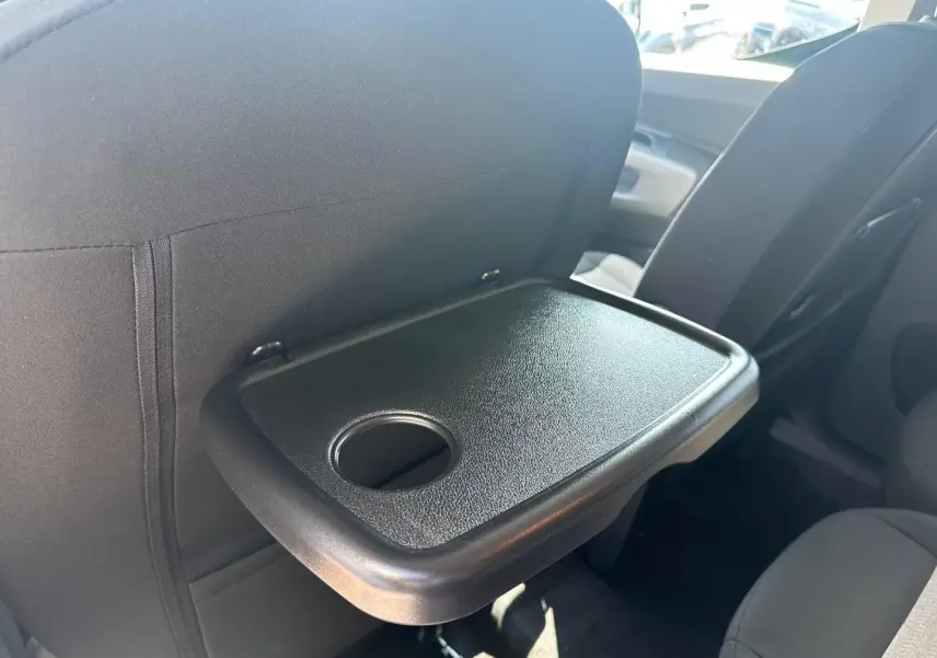 Tablette arrière dépliée avec porte-gobelet sur siège avant, vue intérieure du Citroën Berlingo Kiama Blue.