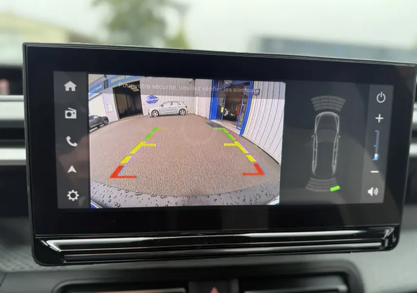 Écran intérieur de la Citroën C3 hybride 2026 montrant la caméra de recul avec lignes de guidage colorées.