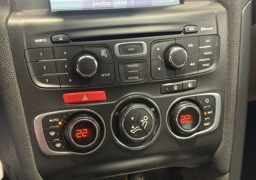 Gros plan sur la console centrale de la Citroën DS4 blanche 2012, montrant les commandes de climatisation et multimédia.