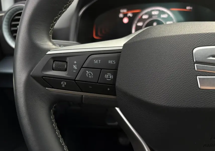 Gros plan sur le volant cuir multifonction de la SEAT Arona avec commandes de régulateur de vitesse et assistance au maintien de voie.