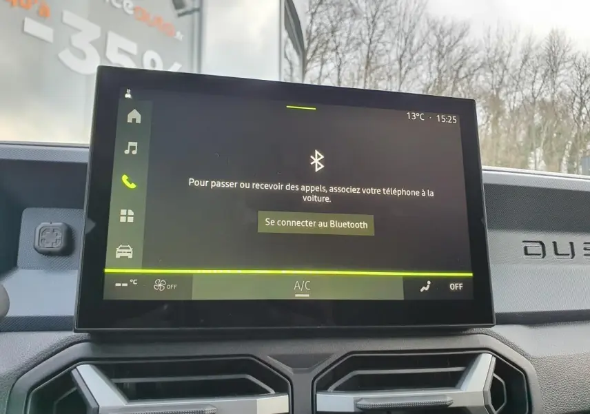 Écran tactile central du Dacia Duster 2025 affichant la connexion Bluetooth, avec tableau de bord gris et logo Duster visible.