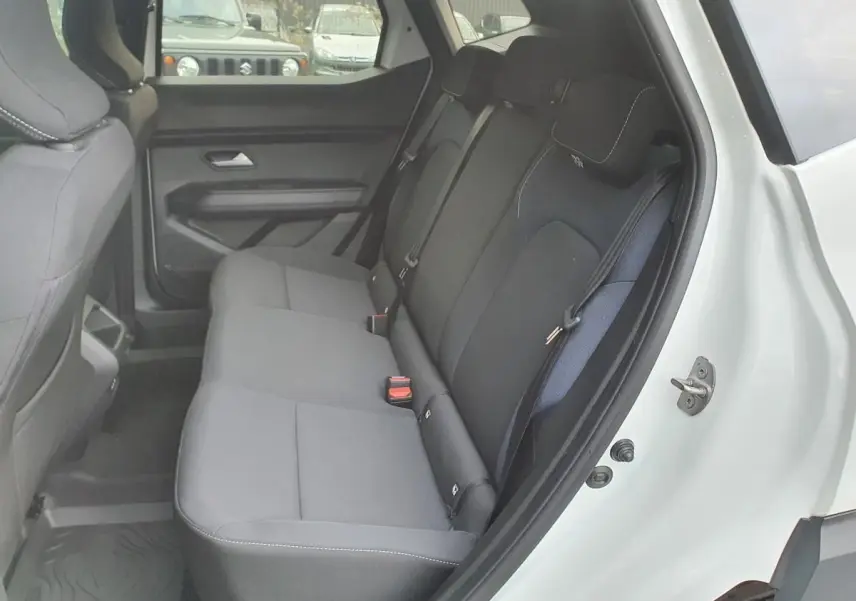 Vue intérieure côté gauche de la banquette arrière noire du Dacia Duster blanc glacier avec ceintures trois points et prises USB.