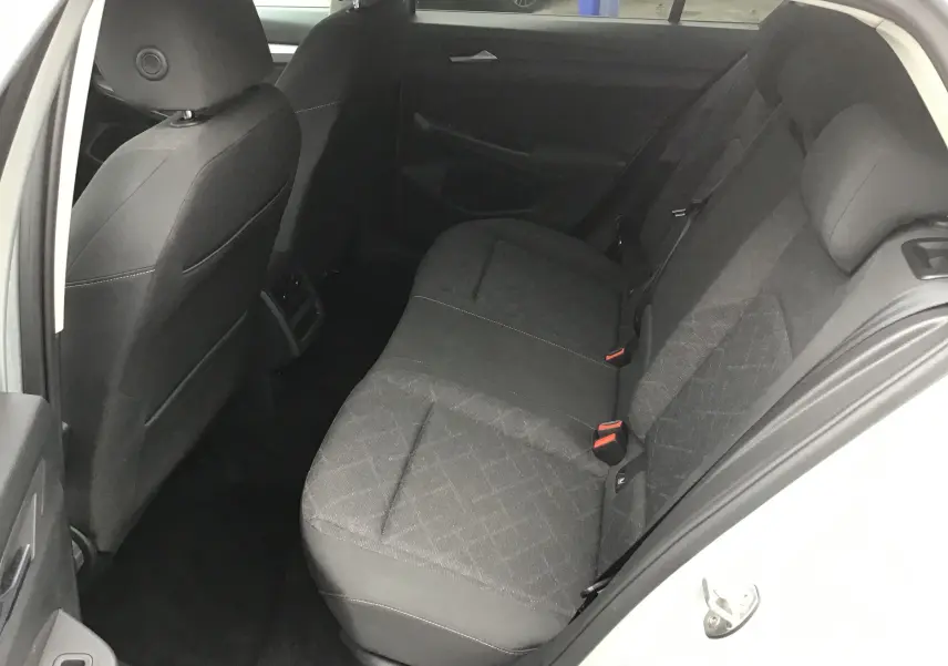 Vue intérieure côté droit des sièges arrière gris foncé d'une Volkswagen Golf VIII 2020, tissu avec motifs discrets.