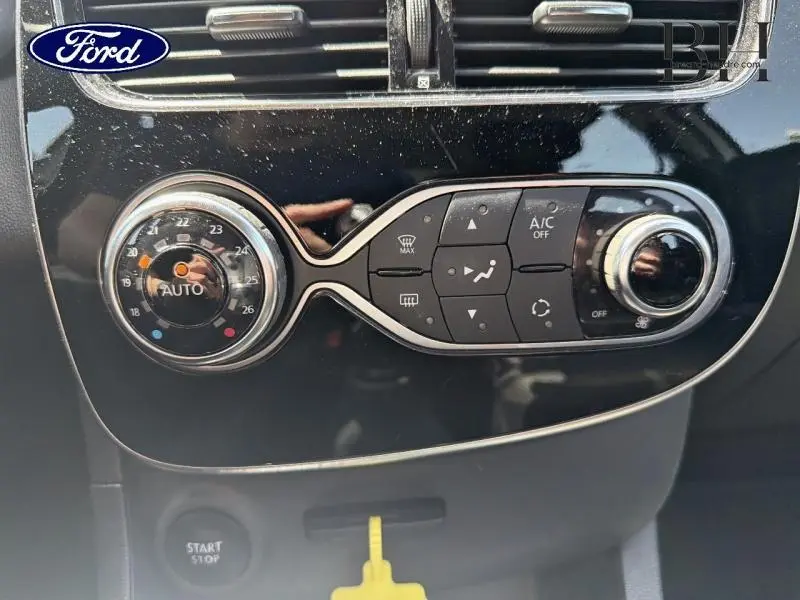 Panneau de commande de climatisation avec réglage automatique dans une Renault Clio blanche vue de face.