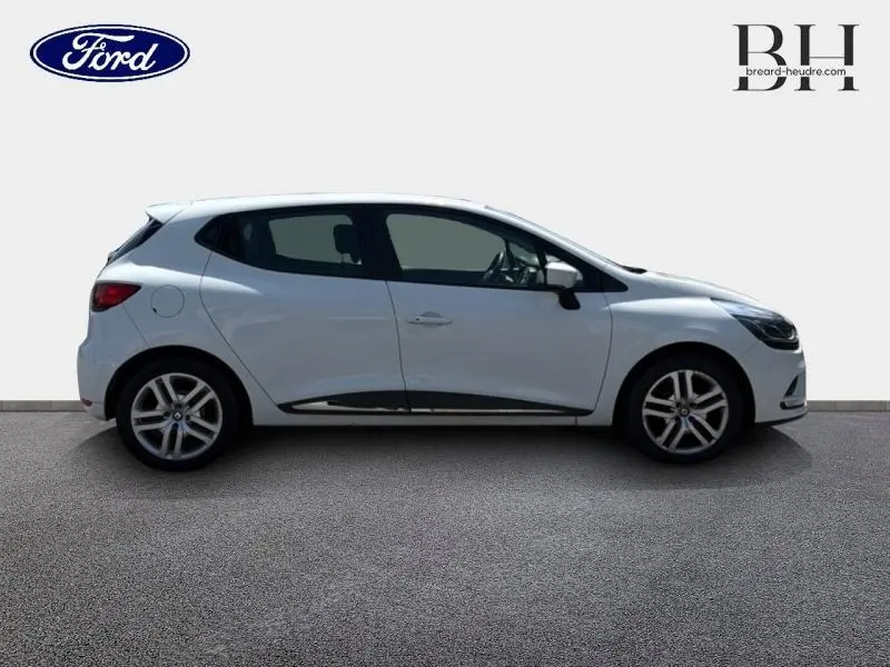 Profil droit d'une Renault Clio blanche 2018 avec jantes alliage et poignées de porte couleur carrosserie.