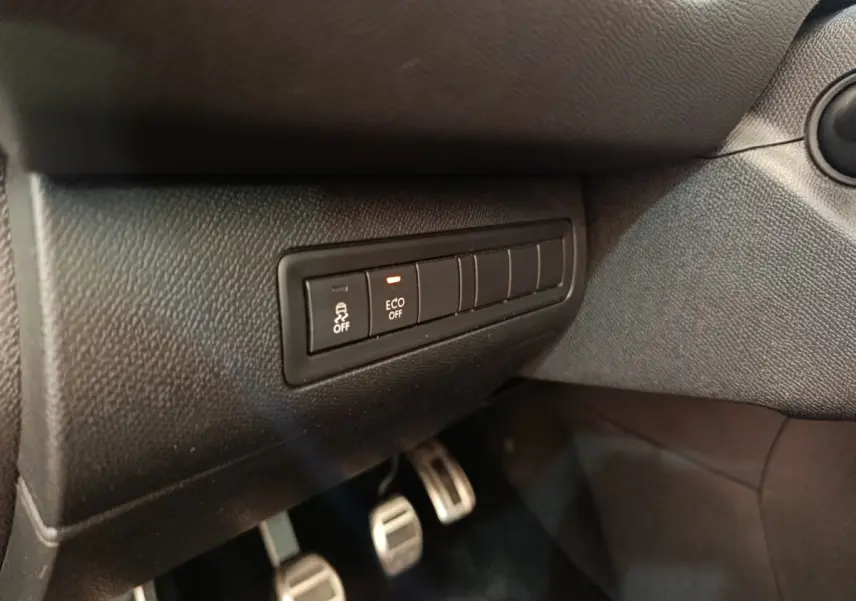 Gros plan sur les commandes de désactivation ESP et mode ECO, tableau de bord noir de la Peugeot 308 GT Line 2016.