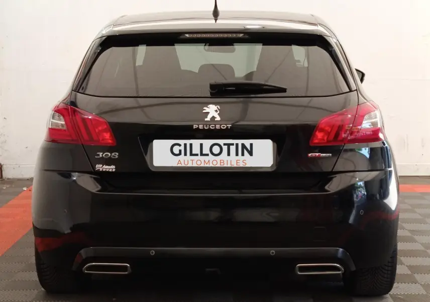 Vue arrière d'une Peugeot 308 noire GT Line de 2016 avec feux rouges et double sortie d'échappement chromée.