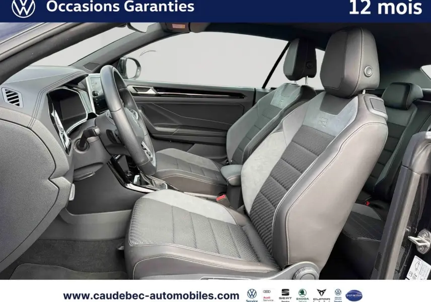 Vue intérieure côté conducteur du Volkswagen T-Roc Cabriolet noir 2025, sièges sport bi-matière avec logo R-Line.