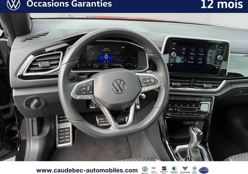 Vue intérieure centrée sur le volant cuir multifonction et tableau de bord numérique du Volkswagen T-Roc Cabriolet noir.