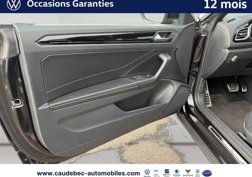 Vue rapprochée de la porte avant gauche noire du Volkswagen T-Roc Cabriolet avec garniture intérieure en cuir et surpiqûres.