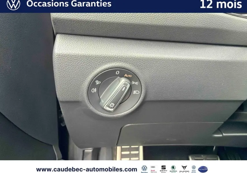 Gros plan sur le bouton de commande des phares dans l'habitacle du Volkswagen T-Roc Cabriolet noir, côté conducteur.