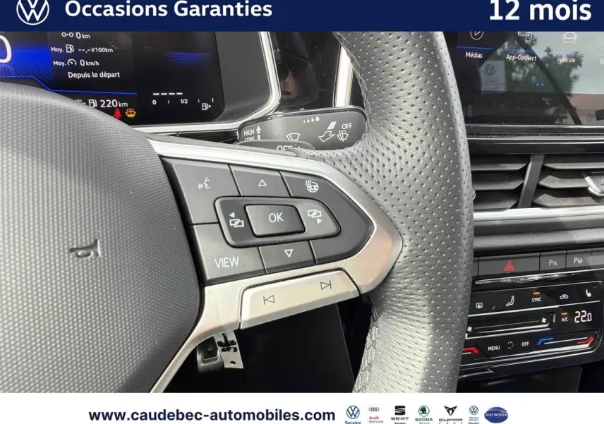 Vue rapprochée du volant multifonction en cuir perforé du Volkswagen T-Roc Cabriolet noir avec tableau de bord digital.
