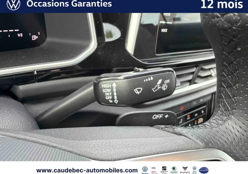 Gros plan sur la manette d'essuie-glace et le volant en cuir perforé du Volkswagen T-Roc Cabriolet noir.