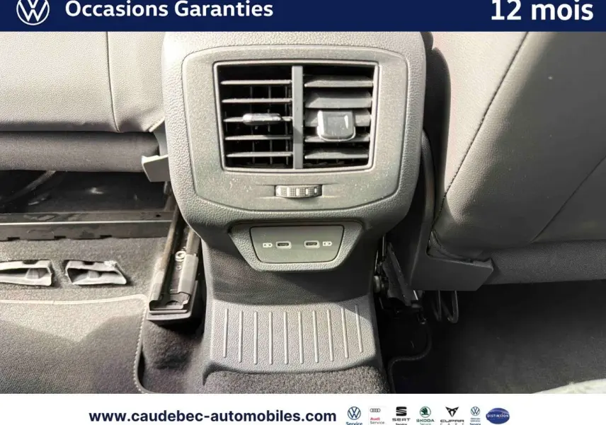 Vue rapprochée de la console arrière du Volkswagen T-Roc Cabriolet noire avec prises USB et sortie d’air centrale.