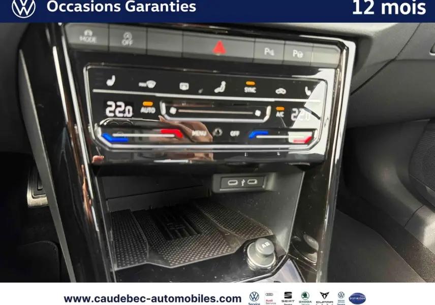 Gros plan sur la console centrale tactile du Volkswagen T-Roc Cabriolet noire, affichant la climatisation bi-zone à 22°C.