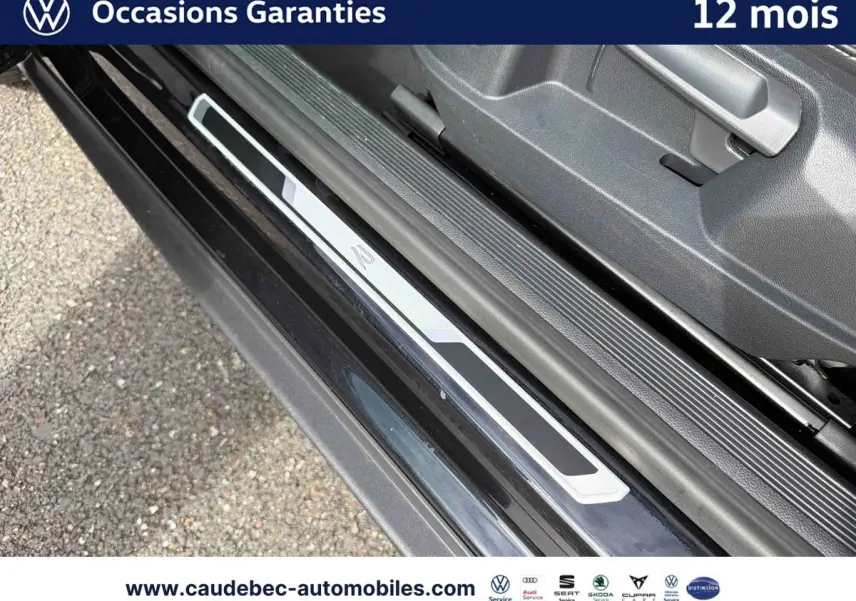 Gros plan sur la plaque de seuil de porte avec logo R-Line du Volkswagen T-Roc Cabriolet noir, côté gauche.
