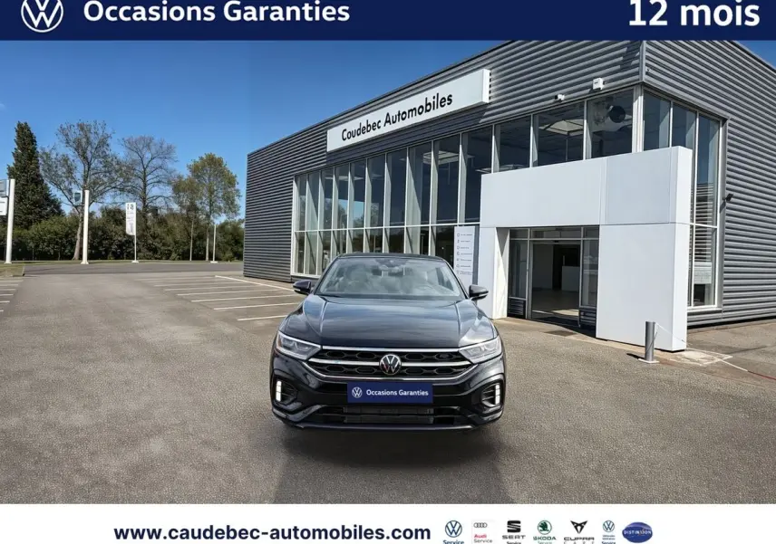 Volkswagen T-Roc Cabriolet noir vue de face, calandre R-Line et feux LED devant un showroom.