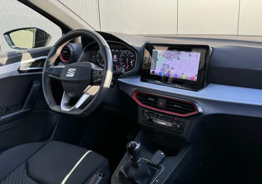 Intérieur SEAT Ibiza TSI 115 FR 2025, vue côté conducteur, tableau de bord avec écran tactile et levier de vitesses manuel.