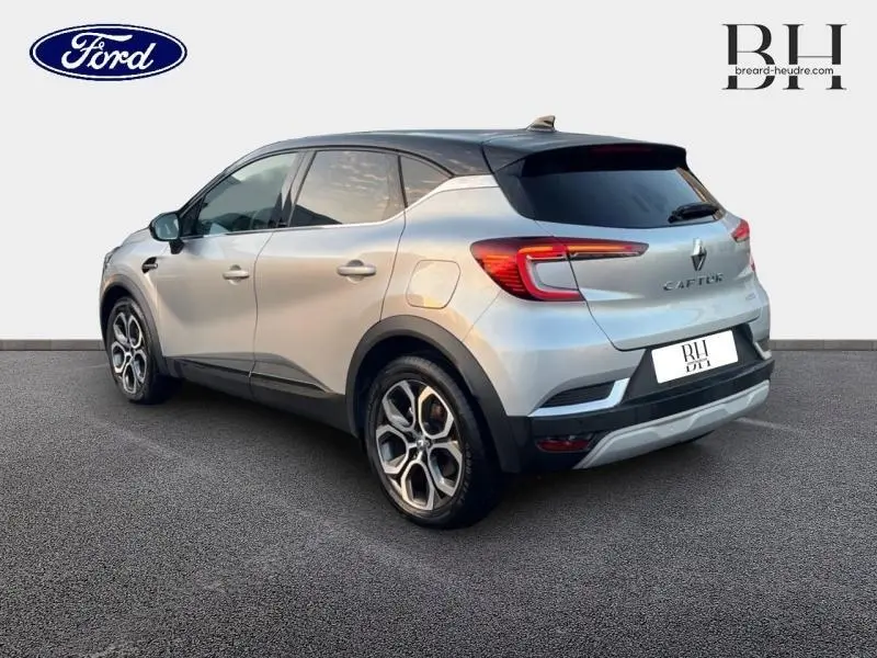 Vue 3/4 arrière droite du Renault Captur gris Highland avec toit noir et jantes alu distinctives.