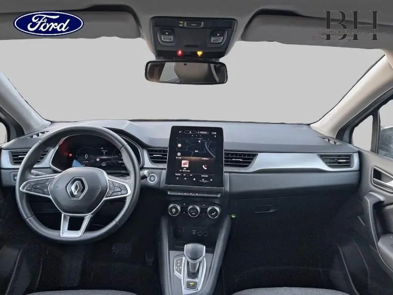 Vue intérieure avant du Renault Captur 1.6 E-Tech hybride rechargeable 2021, tableau de bord noir avec écran tactile vertical central.