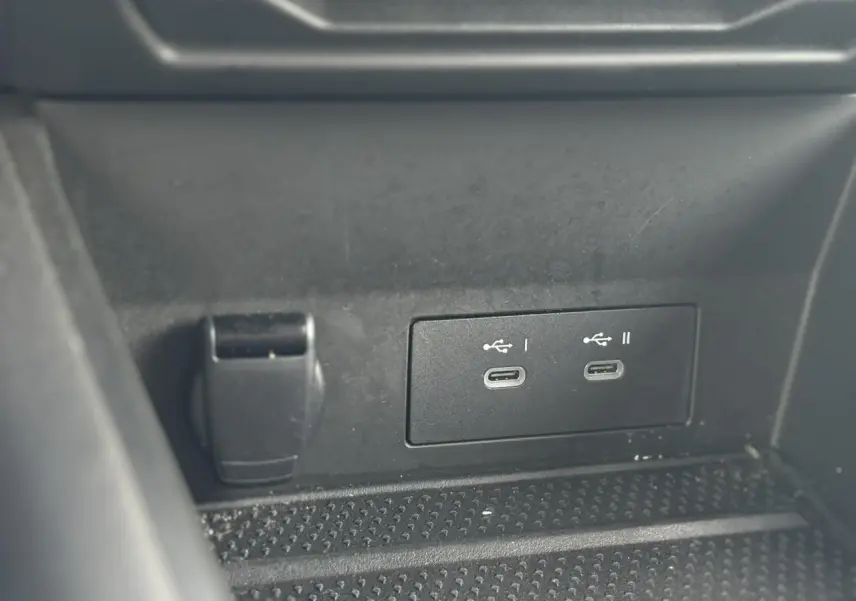 Détail des ports USB-C doubles et prise 12V dans la console centrale noire du Renault Symbioz Bleu Iron.