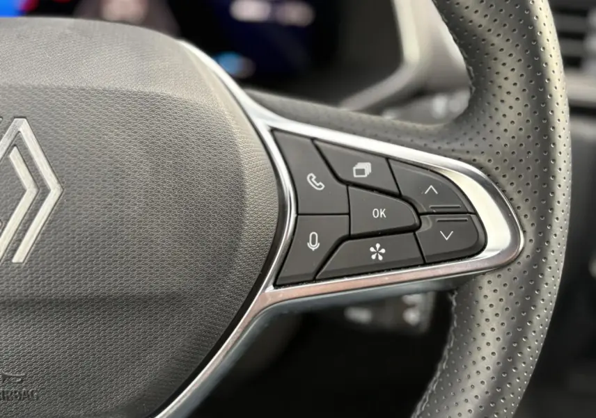 Gros plan sur les commandes multifonctions à droite du volant perforé d'une Renault Symbioz 2025, finition Iconic.