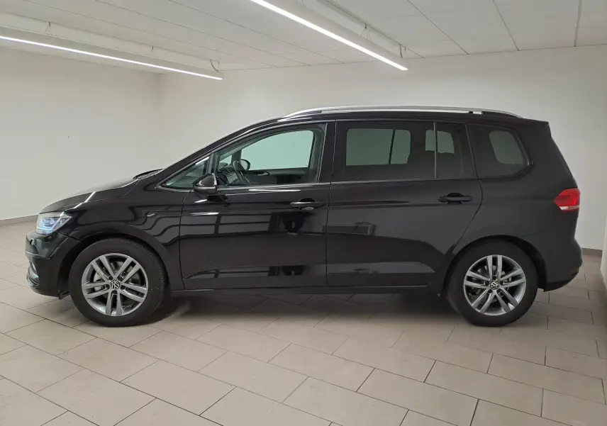 Profil latéral droit du Volkswagen Touran 2025 noir intense nacré avec jantes alliage et vitres teintées.