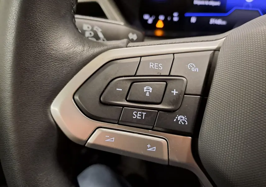 Gros plan sur les commandes au volant du Volkswagen Touran 2025, boutons de régulateur de vitesse et assistance au maintien de voie.