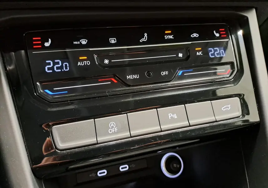 Détail de la console centrale du Volkswagen Touran 2025, affichant la climatisation digitale à 22°C et les commandes de fonctions.