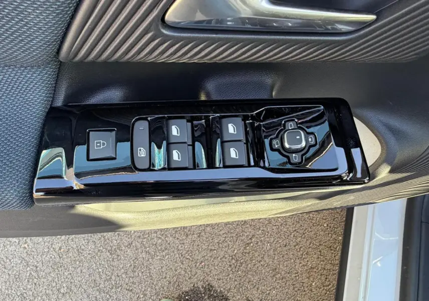 Gros plan sur la commande des vitres et rétroviseurs côté conducteur du Citroën C5 Aircross blanc Okenite.