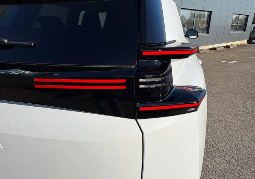 Vue arrière droite du Citroën C5 Aircross blanc Okenite avec feux arrière LED horizontaux rouges et toit noir brillant.