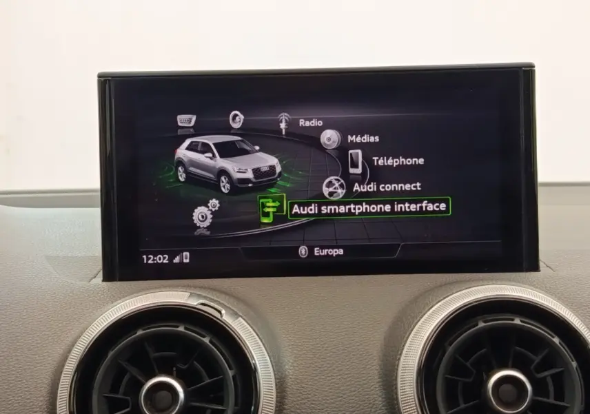 Écran central tactile montrant l'interface multimédia d'une Audi Q2 35 TFSI noire, tableau de bord en arrière-plan.