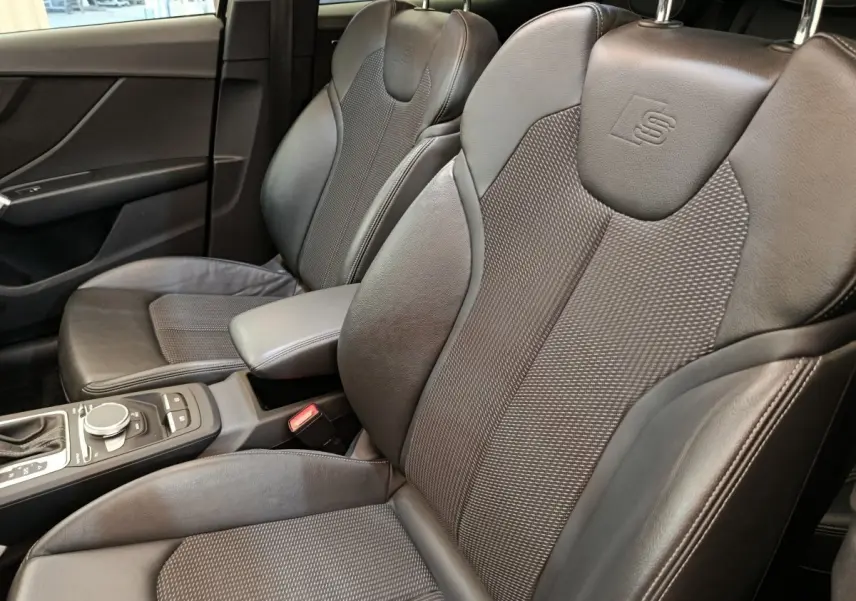 Vue rapprochée des sièges avant en cuir noir avec logo S embossé dans l’Audi Q2 35 TFSI S Line 2021.