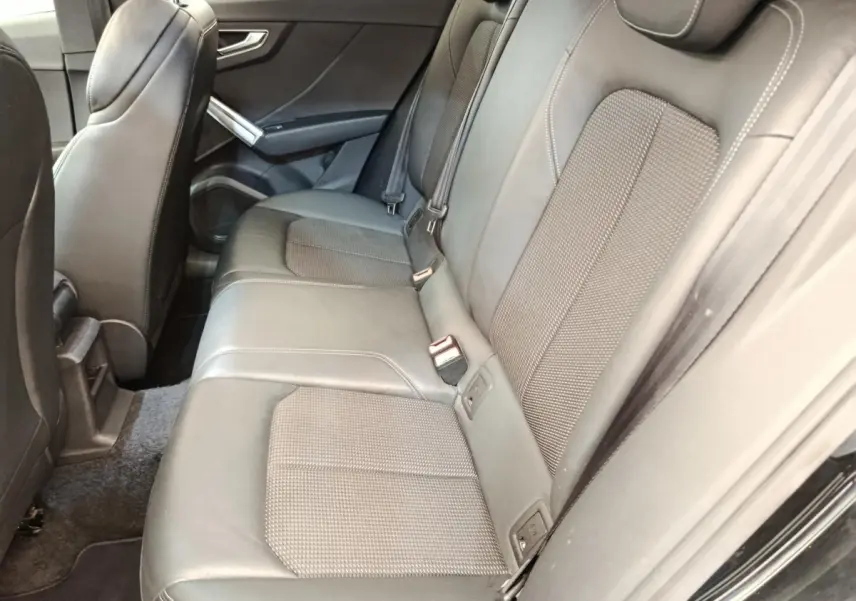 Vue latérale intérieure montrant la banquette arrière noire en cuir de l'Audi Q2 35 TFSI S Line 2021.