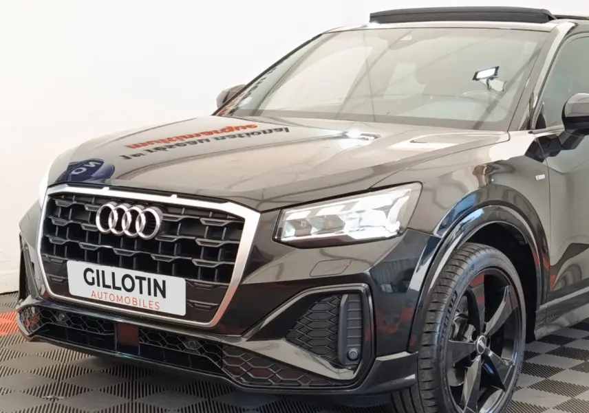 Audi Q2 35 TFSI S Line noir vue 3/4 avant droit, avec calandre hexagonale et jantes noires distinctives.