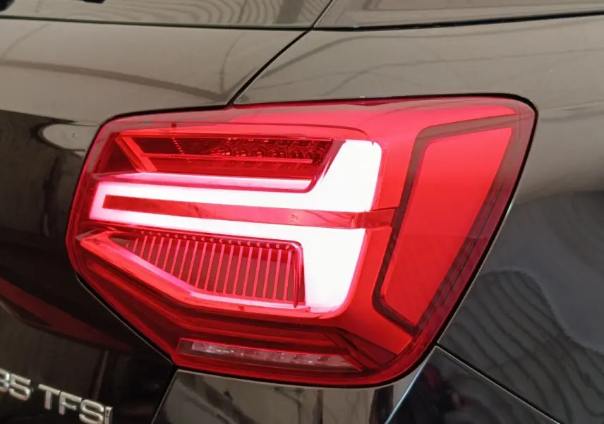 Gros plan sur le feu arrière droit rouge et blanc d’un Audi Q2 noir 35 TFSI 150 S Tronic S Line de 2021.