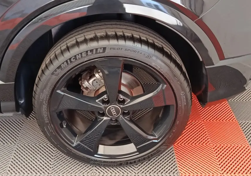 Gros plan sur la roue arrière droite noire d’un Audi Q2 35 TFSI S Line avec jante cinq branches et pneu Michelin.