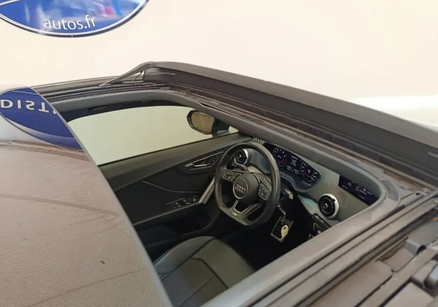 Vue intérieure côté conducteur de l'Audi Q2 noir 2021, volant cuir multifonctions et tableau de bord digital.