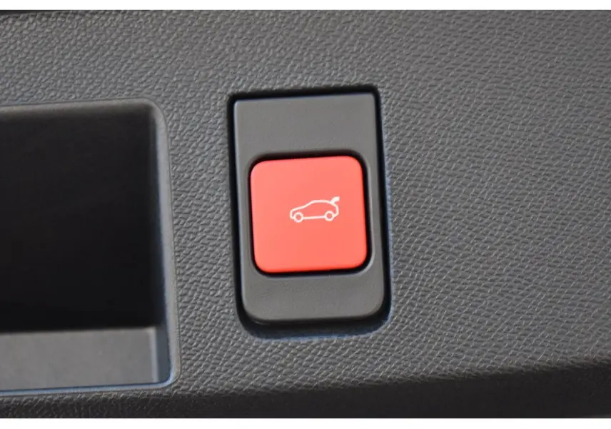 Gros plan sur le bouton rouge d'ouverture du hayon motorisé du Citroën C5 Aircross blanc hybride 2026.