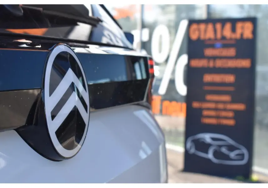 Gros plan sur l'arrière blanc d'un Citroën C5 Aircross hybride avec logo Citroën brillant noir et chrome.