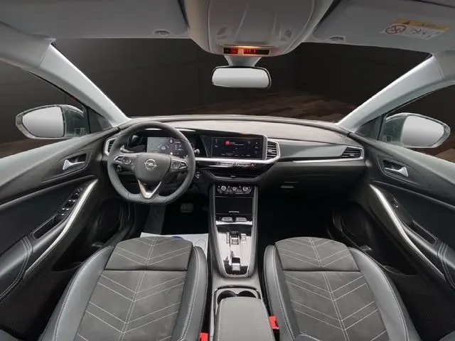 Intérieur noir de l'Opel Grandland 2024, vue frontale du tableau de bord avec écran tactile et volant multifonction.